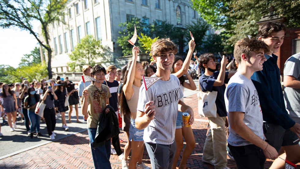 A student waves a Brown pennant during the Convocation procession.